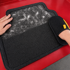 Pet hair remover glove lifting pet hair from a car floor mat